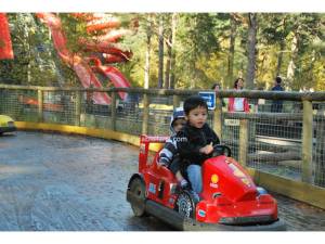 Raed dan Hakim bermain kereta, berlatarbelakangkan water slide di Landmark Park